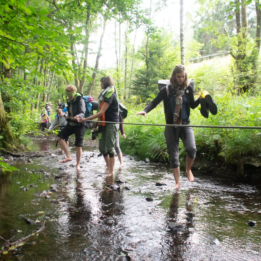 Inklusions-Wanderung durch einen Fluss